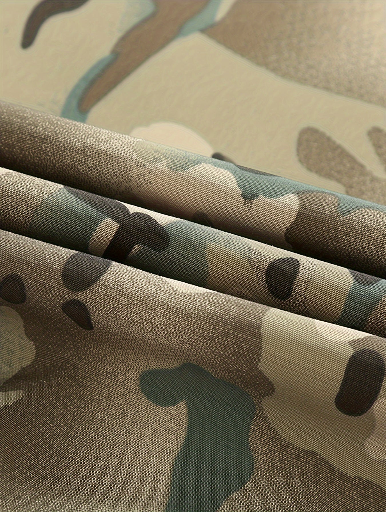 Close-up of camouflage fabric with brown, green, and black patterns.