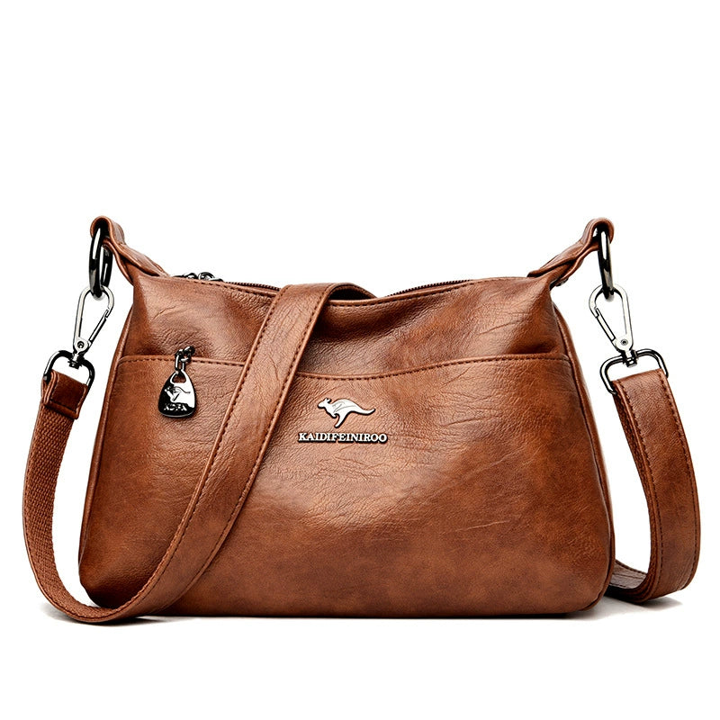 Brown leather handbag with a visible brand logo on a white background
