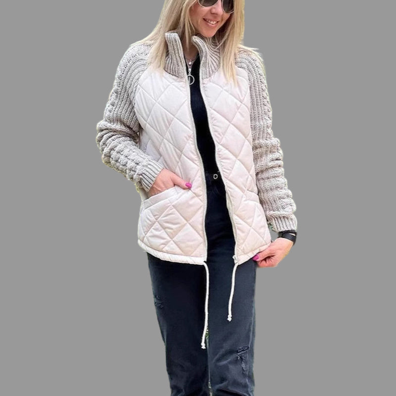 Woman wearing a white quilted vest over a gray knit cardigan in an outdoor setting.