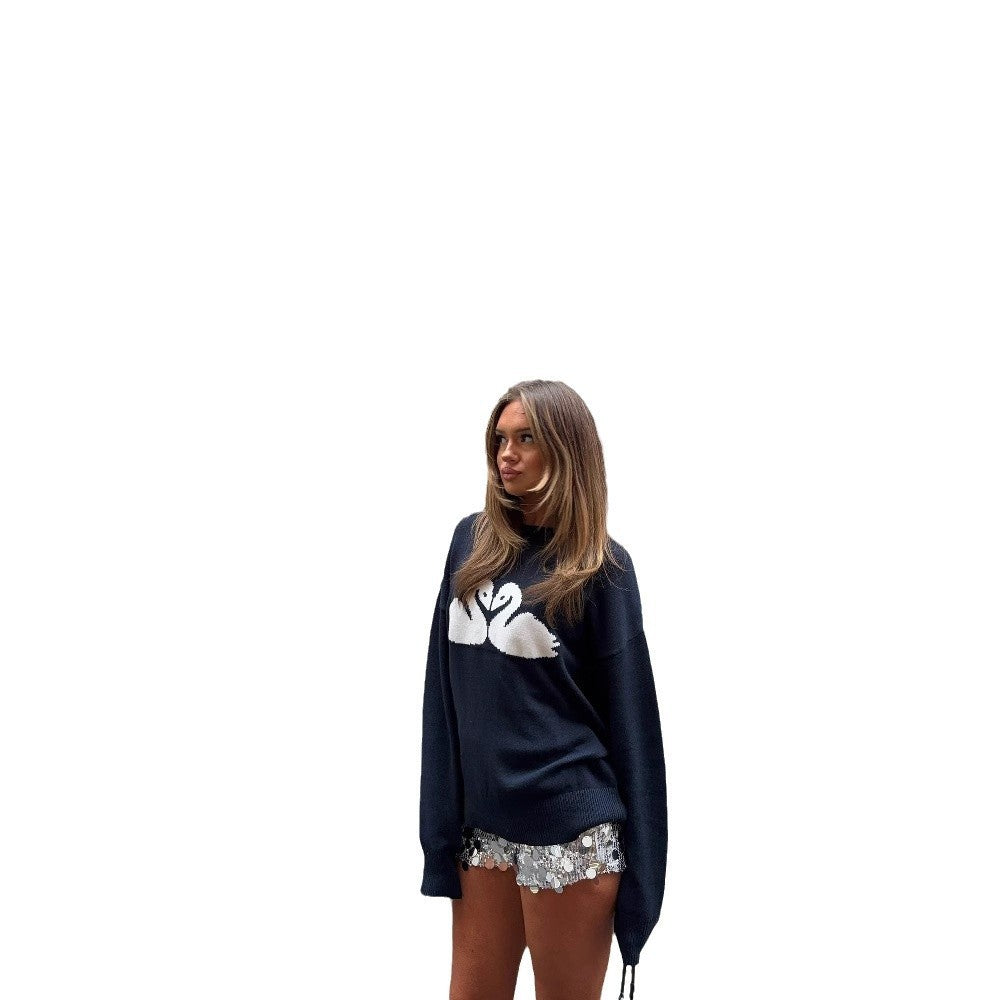 Woman wearing a navy blue sweater with a white logo on a white background