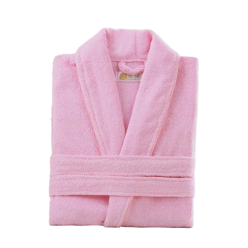 Pink bathrobe on a wooden surface with a wicker basket and flowers in the background