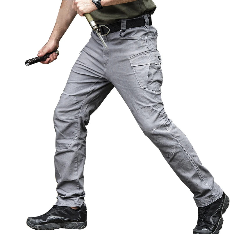 Person wearing gray tactical pants with a white background