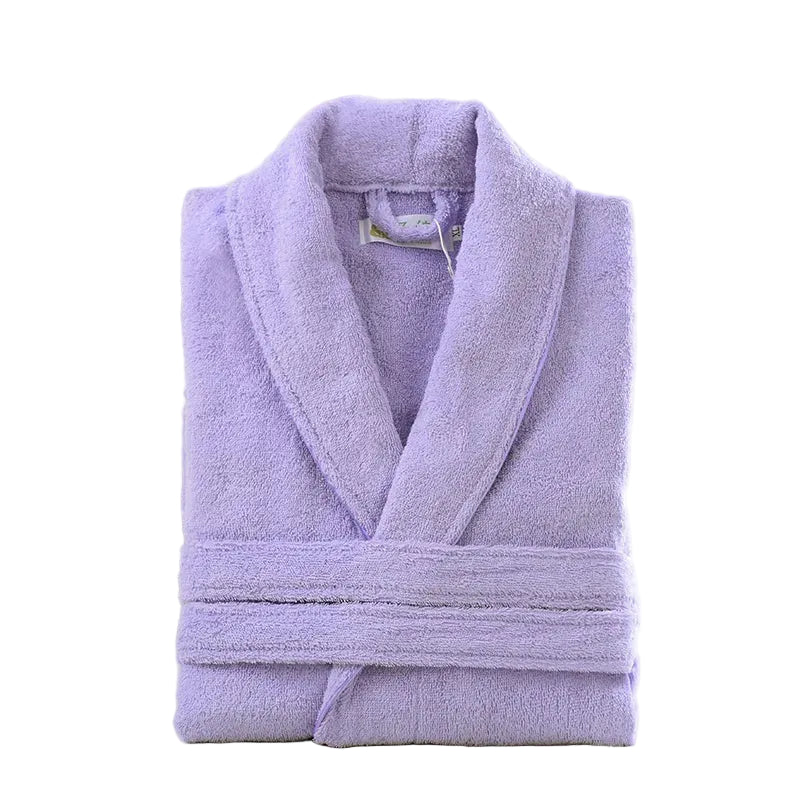 Folded lavender robe on a white surface with a wicker basket and flowers in the background