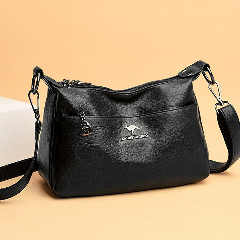 Black handbag with a visible brand logo on a beige background