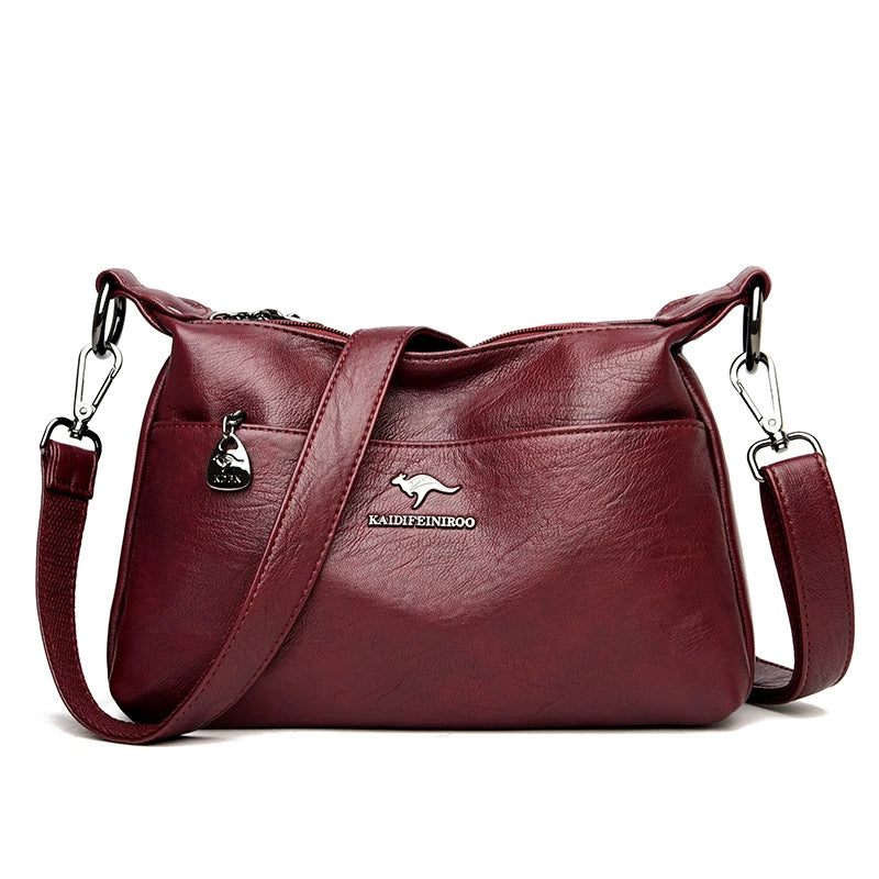 Maroon handbag with a visible brand logo on a white background