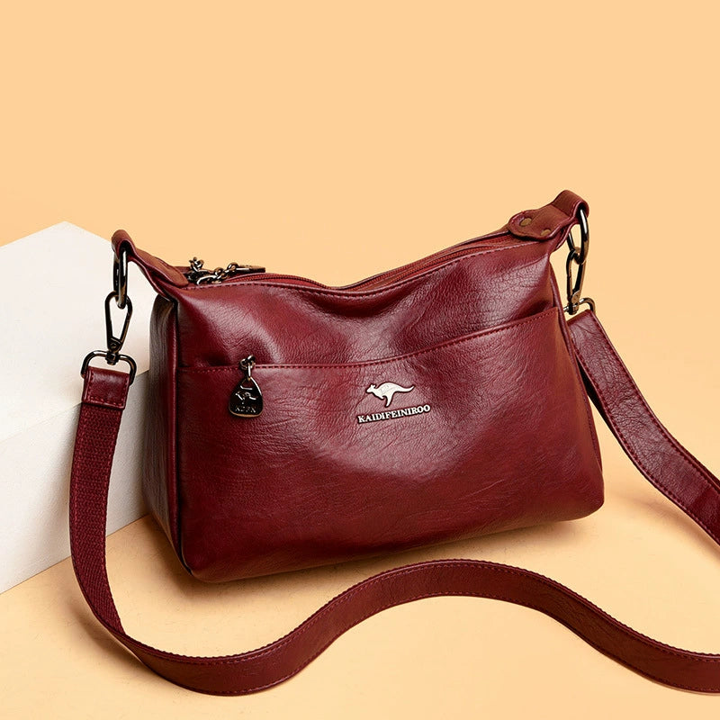 Red handbag with a visible brand logo on a beige background