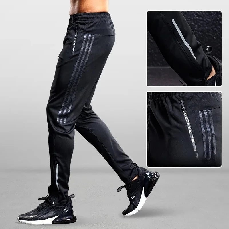 Black athletic pants with reflective stripes on a gray background