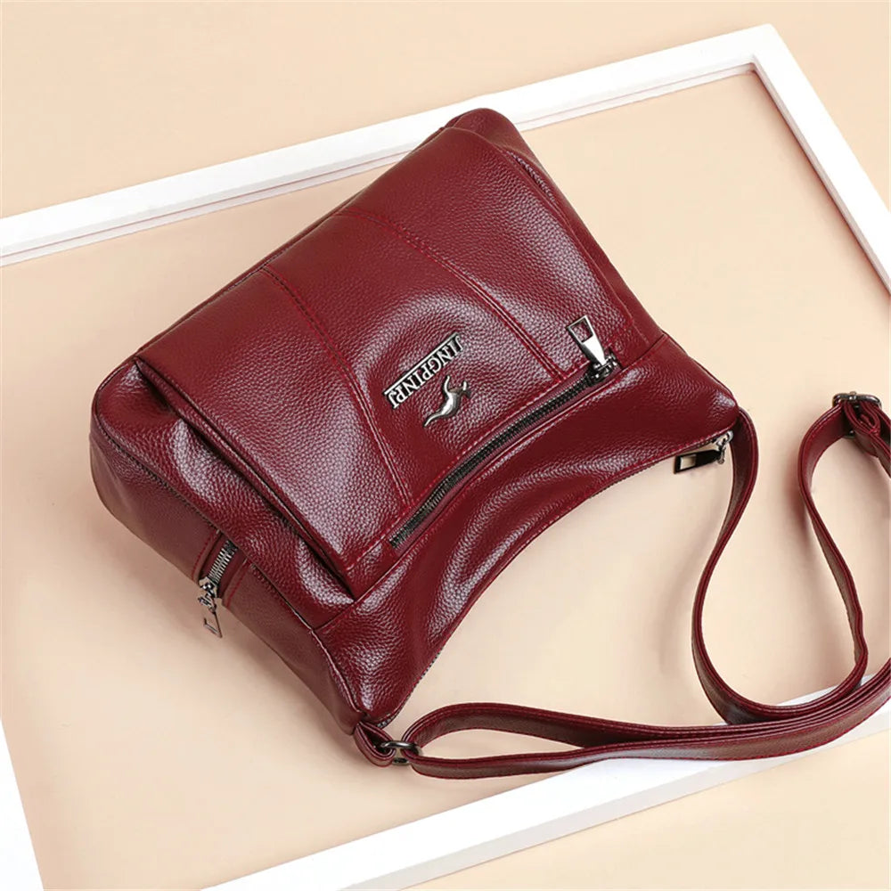 Red leather handbag with a visible brand logo on a beige background