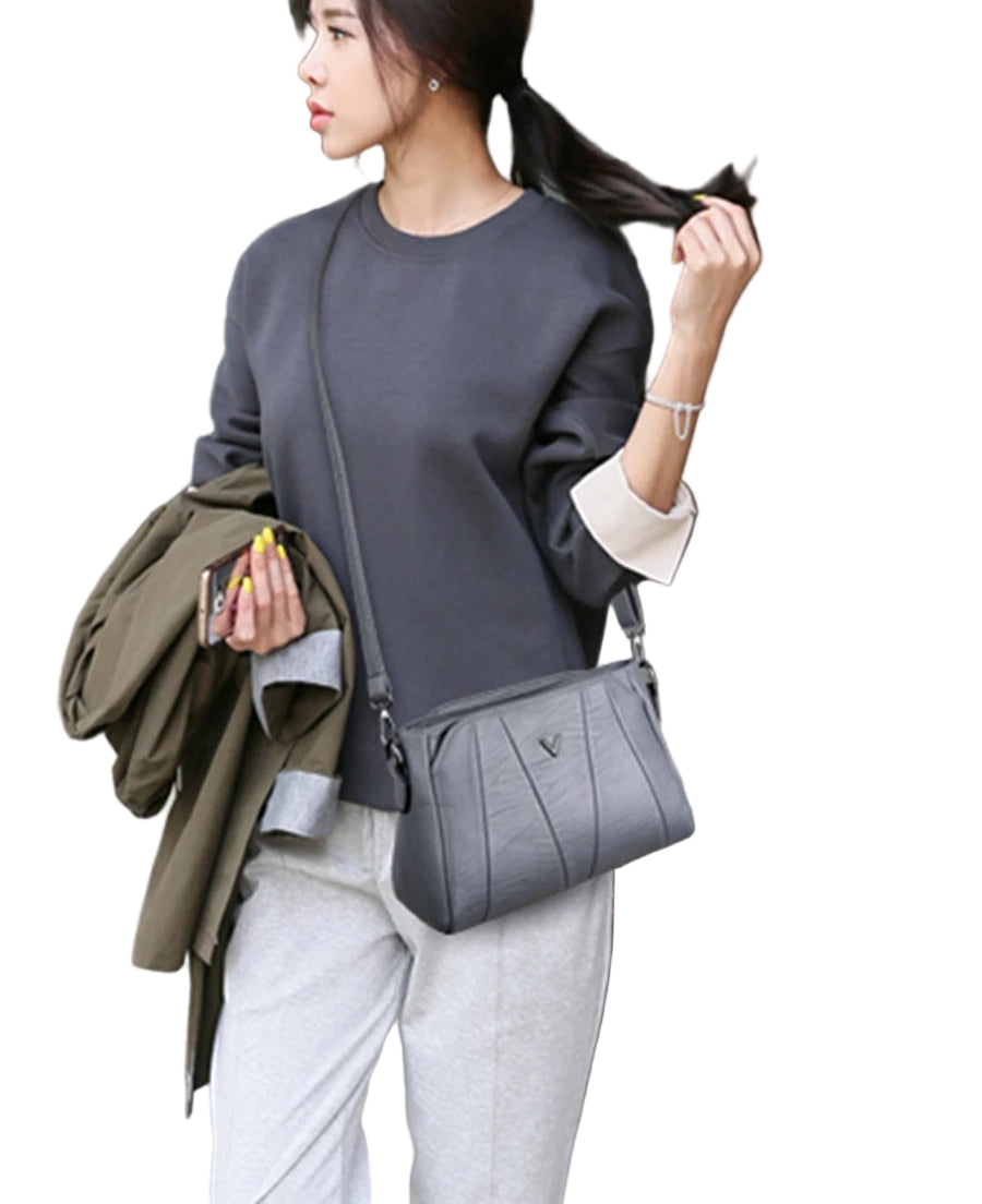 Woman holding a gray handbag with a blurred background
