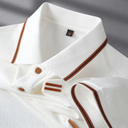 Close-up of a white shirt with brown accents on a gray background