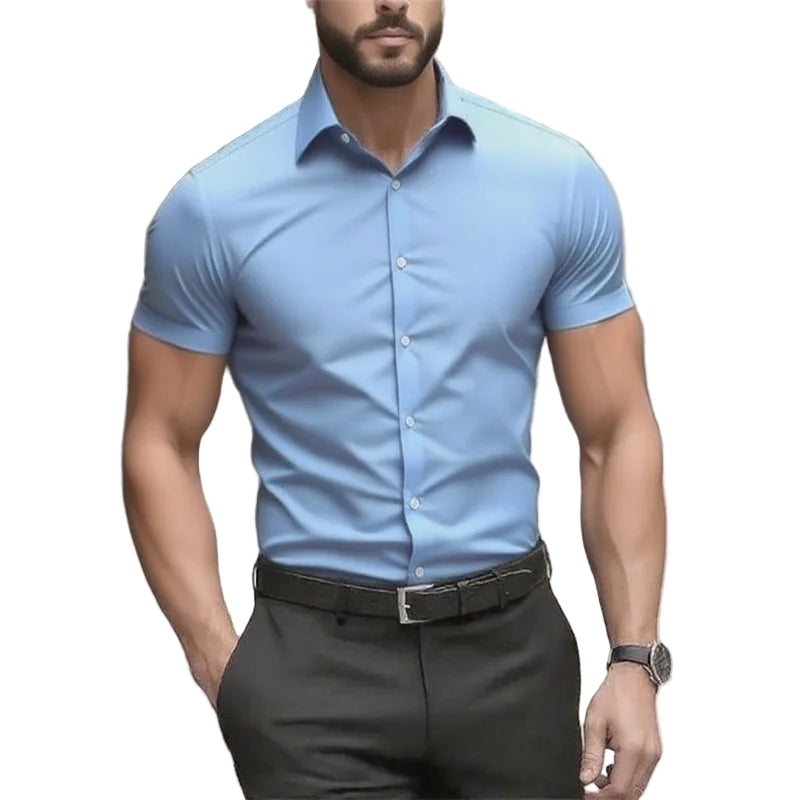 Man wearing a light blue short-sleeve dress shirt and dark pants outdoors.