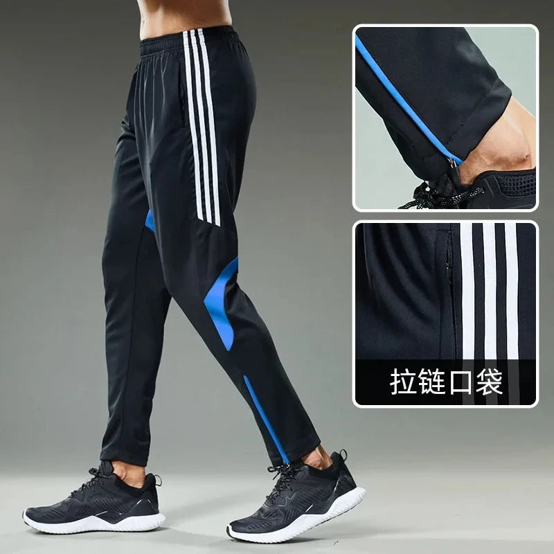 Black athletic pants with white stripes and blue accents on a gray background