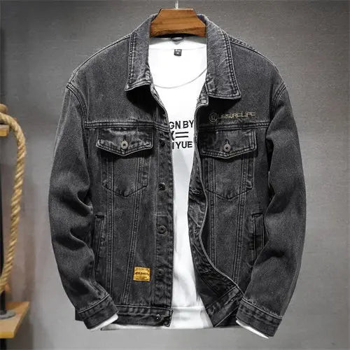 Black denim jacket on a hanger against a gray background