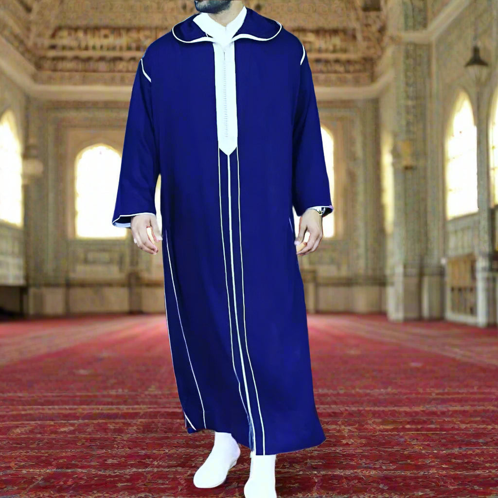 Person wearing a blue and white traditional outfit on a red carpet with a blurred background