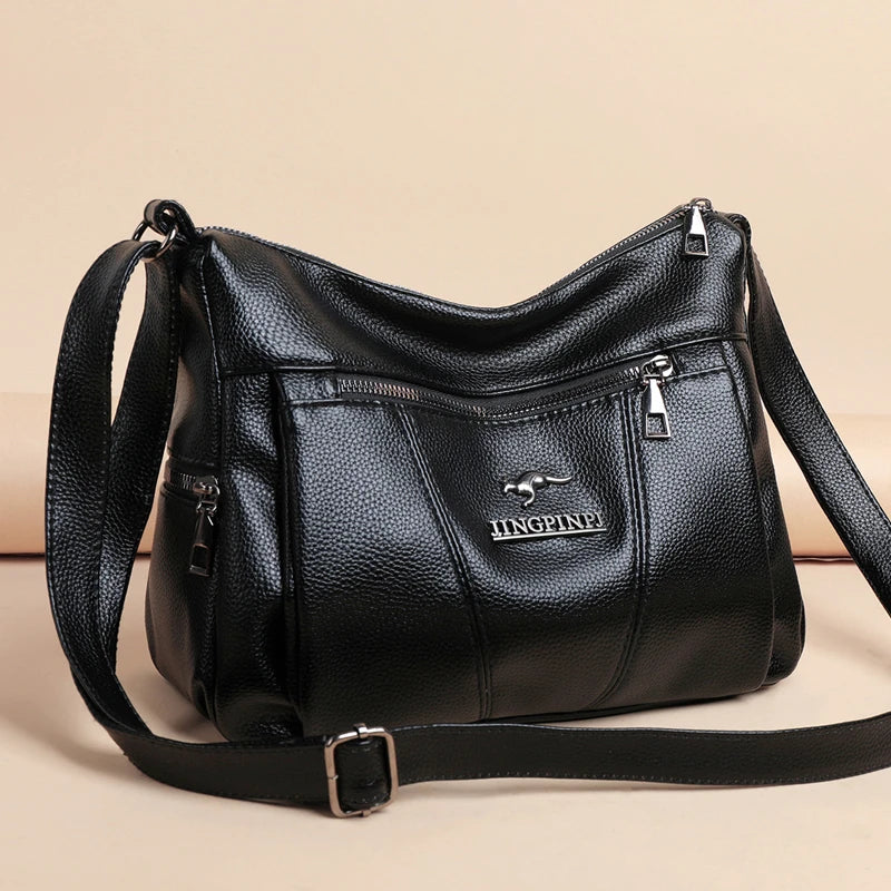 Black leather handbag with a visible brand logo on a beige background