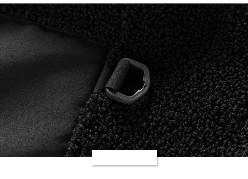 Close-up of a black fabric with a metal buckle on a textured black background.
