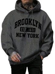 Person wearing a gray hoodie with 'Brooklyn Est. 1631 New York' text on a street.