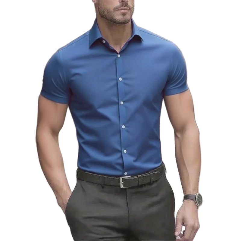 Man wearing a blue short-sleeve dress shirt and dark pants outdoors.