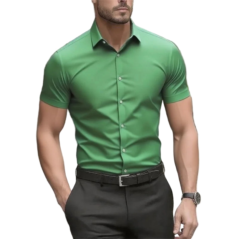 Man wearing a green shirt and black pants with a blurred background