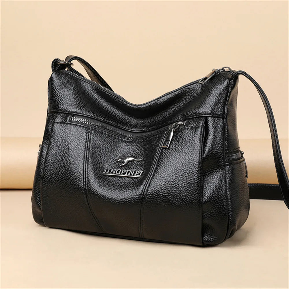 Black leather handbag with visible brand logo on a beige background