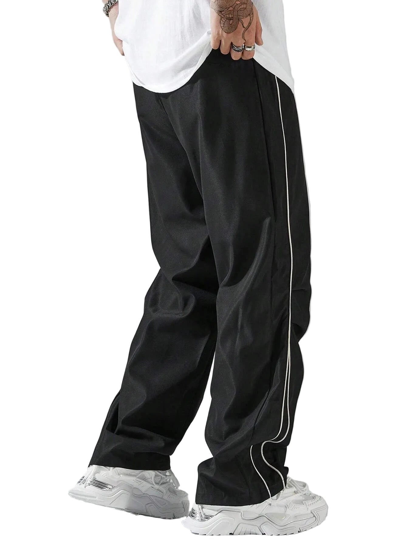 Person wearing black pants with white stripes on a gray background