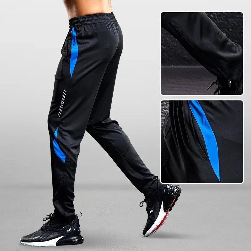 Black athletic pants with blue accents worn by a person on a gray background