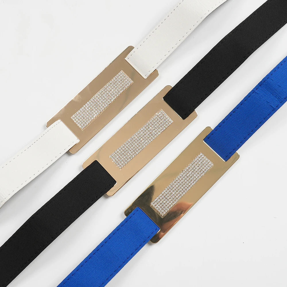 Three belts with metallic buckles on a white background