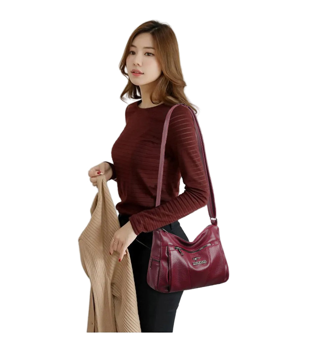 Woman holding a red handbag and a beige coat on a white background