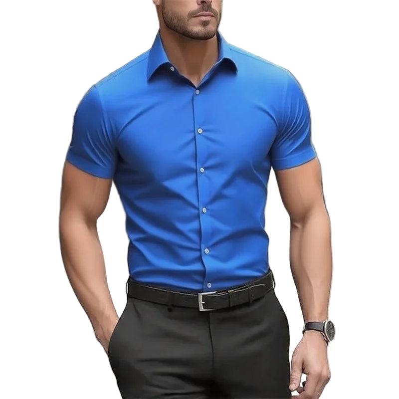 Man wearing a blue short-sleeve dress shirt and black pants on a blurred street background