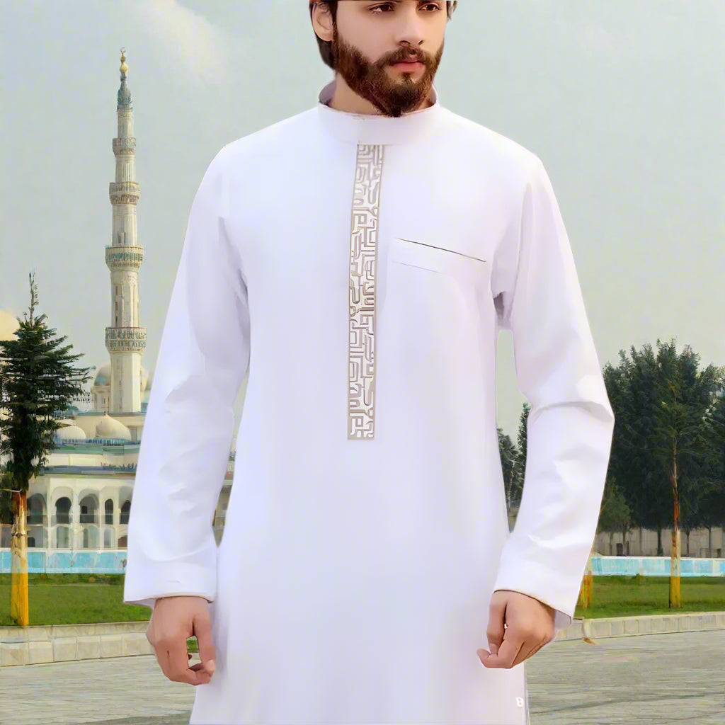 Man wearing a white traditional outfit with embroidery on a blurred background
