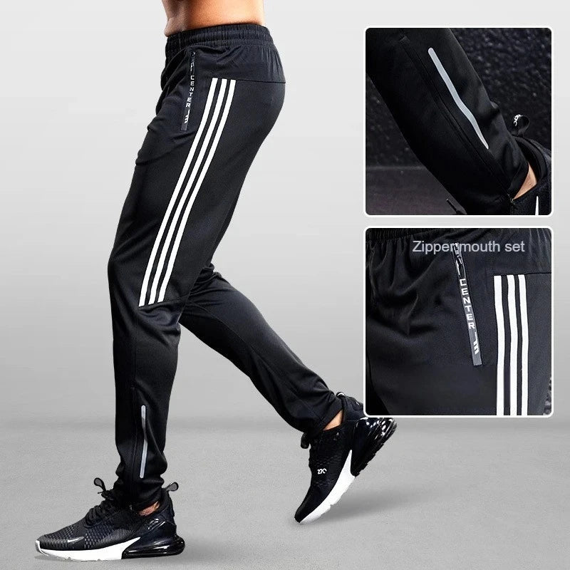 Black athletic pants with white stripes worn by a person on a gray background