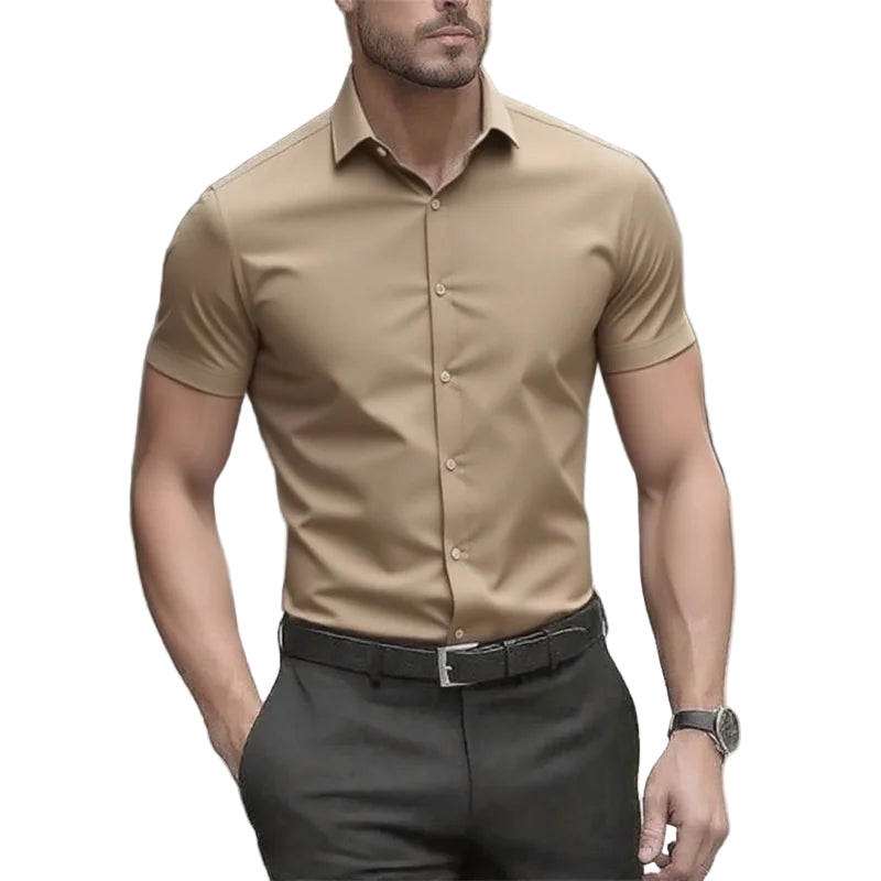 Man wearing a beige short-sleeve shirt and dark pants on a blurred street background
