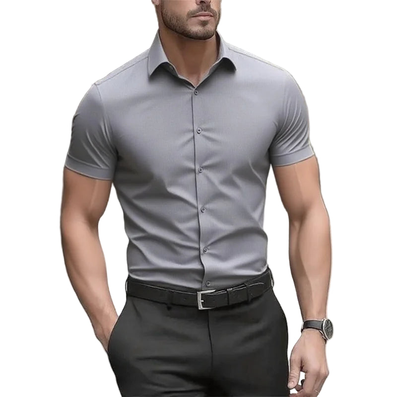 Man wearing a gray short-sleeve dress shirt and black pants on a blurred street background