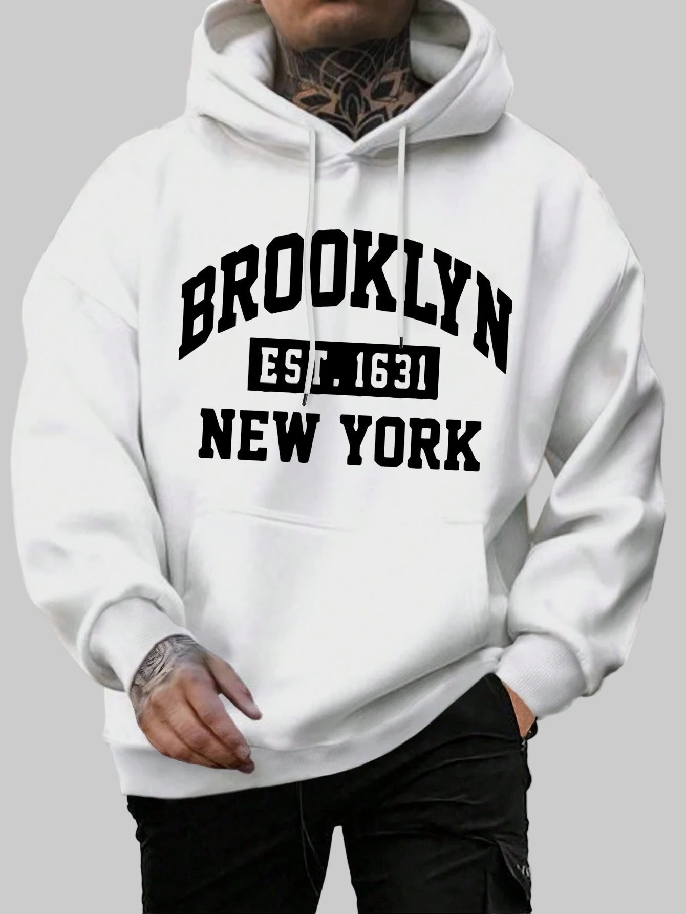 Person wearing a white hoodie with 'Brooklyn Est. 1631 New York' text on a street background